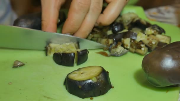 Flicka en kniv skivad kokt aubergine för sallad. — Stockvideo