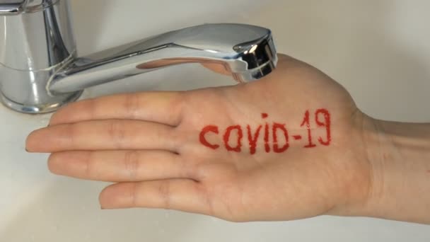 Schreiben Sie auf der Hand covid-19. Frauen waschen die Hände am besten zu Hause Coronavirus Spülwasser reiben Seife trockenes Handtuch extreme Nahaufnahme. Stoppt die Ausbreitung des Coronavirus. — Stockvideo