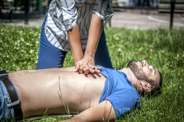 cardiac massage to an unconscious guy after injury clipart