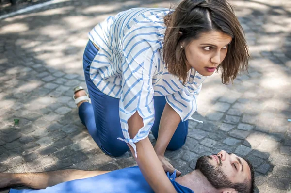 Girl trying to find help for an unconscious guy — Stock Photo, Image