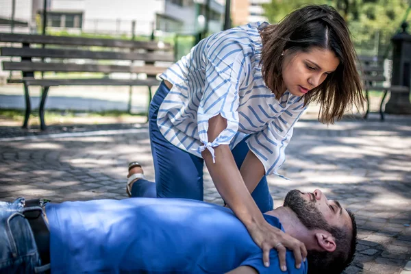 Menina tentando encontrar ajuda para um inconsciente cara — Fotografia de Stock