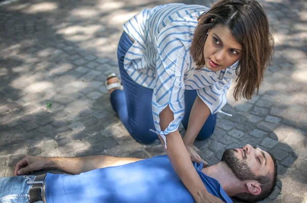 Menina tentando encontrar ajuda para um inconsciente cara — Fotografia de Stock