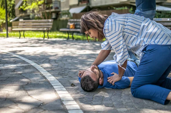 Baygın bir adam için yardım bulmaya çalışırken kız — Stok fotoğraf