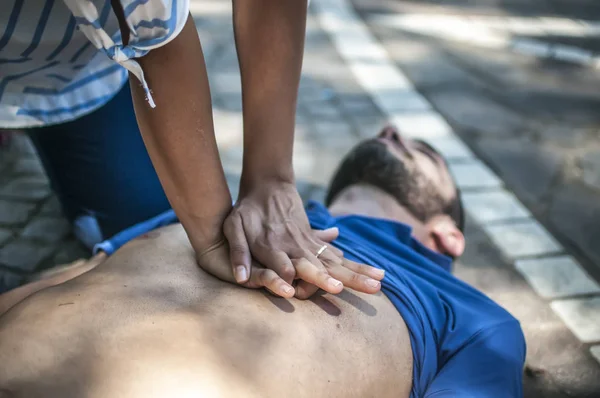 Menina fazendo ressuscitação cardiopulmonar para um cara inconsciente após ataque cardíaco — Fotografia de Stock