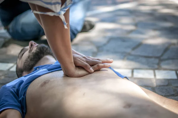 Niña haciendo resucitación cardiopulmonar a un hombre inconsciente después de un ataque al corazón —  Fotos de Stock