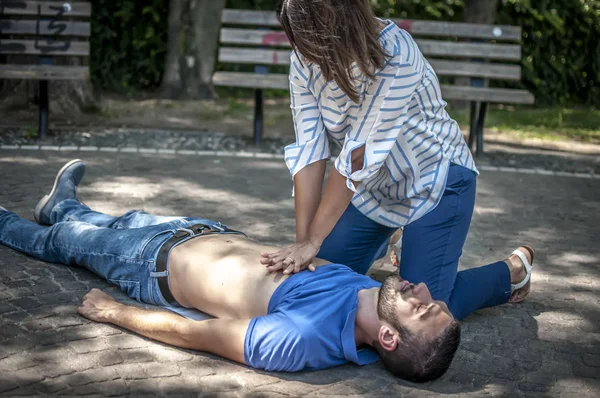 Dívka dělat kardiopulmonální resuscitace do bezvědomí chlapa po infarktu — Stock fotografie