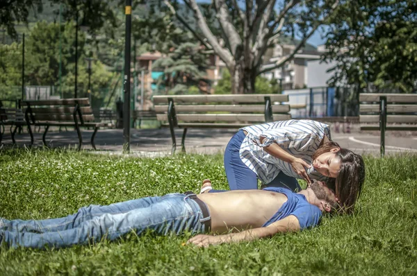 Chica comprobar los parámetros vitales de un hombre inconsciente después de un ataque al corazón — Foto de Stock