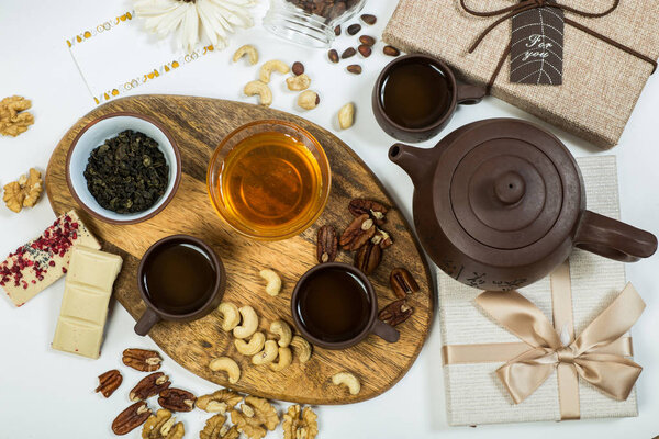 Healthy eating. Cups with tea, honey, nuts and natural white chocolate. Flat lay.