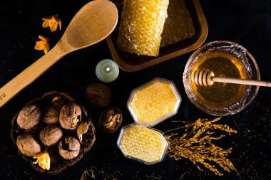 Tatlım, petek ve siyah arka plan üzerine ceviz