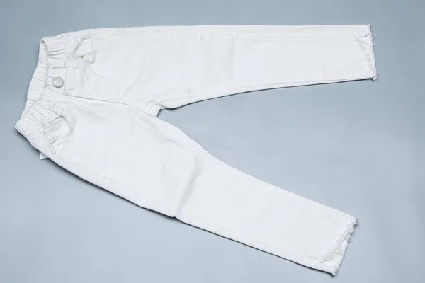灰色背景的白色牛仔裤 顶部视图 — 图库照片