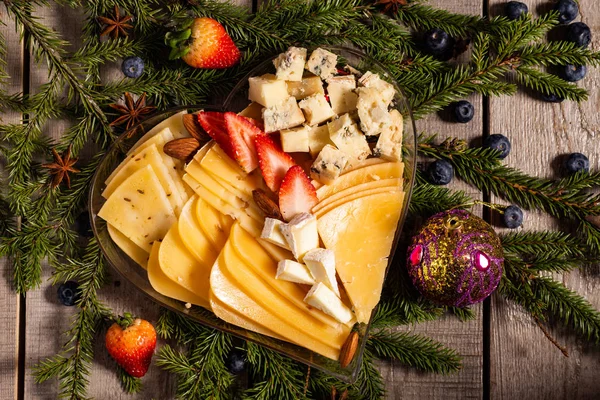 Farklı tipte lezzetli peynirli tabaklar Noel ağacı dallarında. 