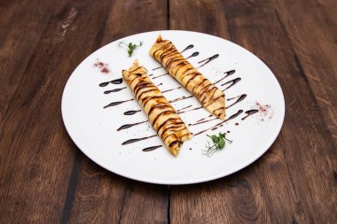 Tahta bir masada çilekli ve ahududulu ince krepler..