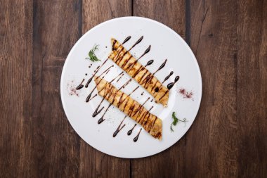 Ahşap bir masada çilekli ve ahududulu ince krepler. Üst görünüm.