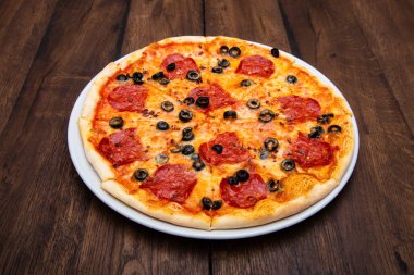 Klasik İtalyan pizzası ahşap bir masada.