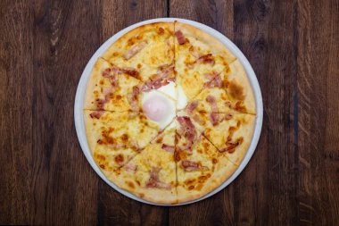 Klasik İtalyan pizzası ahşap bir masada.