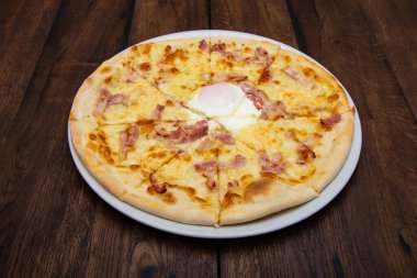 Klasik İtalyan pizzası ahşap bir masada.