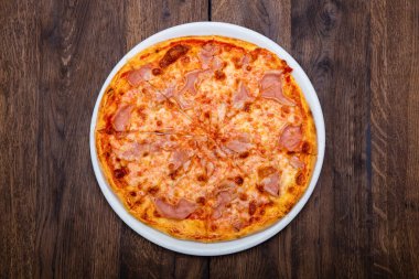 Klasik İtalyan pizzası ahşap bir masada.