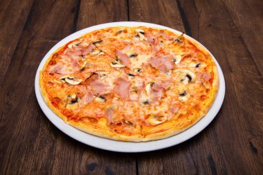 Klasik İtalyan pizzası ahşap bir masada.