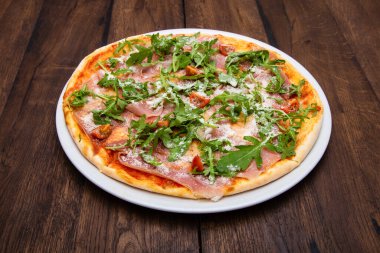 Klasik İtalyan pizzası ahşap bir masada.