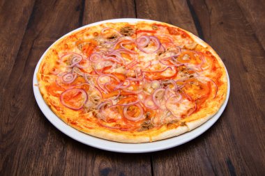 Klasik İtalyan pizzası ahşap bir masada.