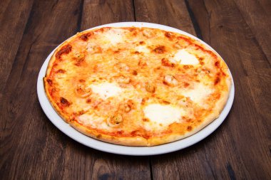 Klasik İtalyan pizzası ahşap bir masada.