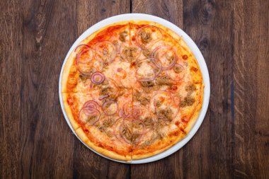 Klasik İtalyan pizzası ahşap bir masada.