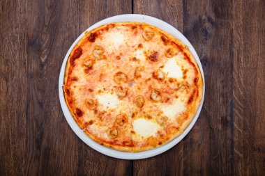 Klasik İtalyan pizzası ahşap bir masada.