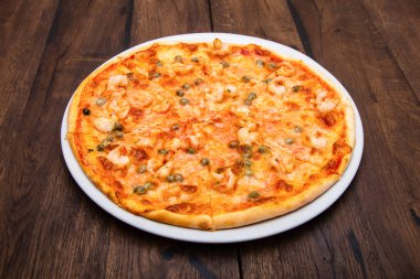 Klasik İtalyan pizzası ahşap bir masada.
