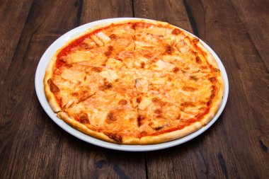 Klasik İtalyan pizzası ahşap bir masada.