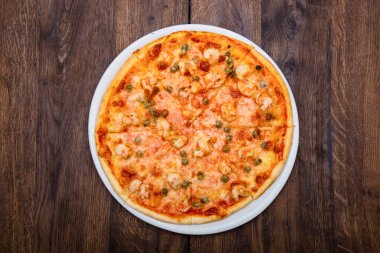 Klasik İtalyan pizzası ahşap bir masada.