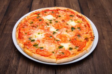 Klasik İtalyan pizzası ahşap bir masada.