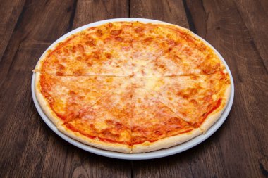 Klasik İtalyan pizzası ahşap bir masada.