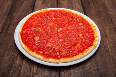 Klasik İtalyan pizzası ahşap bir masada.