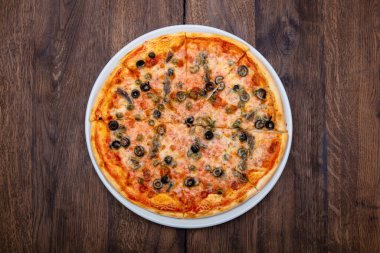 Klasik İtalyan pizzası ahşap bir masada.