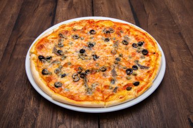 Klasik İtalyan pizzası ahşap bir masada.