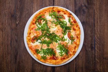 Klasik İtalyan pizzası ahşap bir masada.