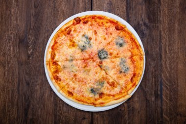 Klasik İtalyan pizzası ahşap bir masada.