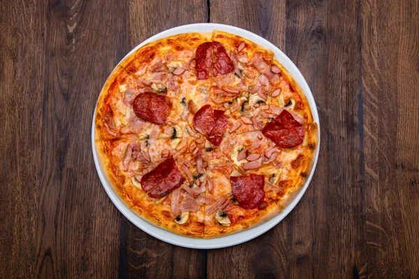 Klasik İtalyan pizzası ahşap bir masada.