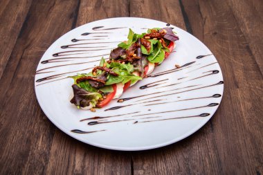 Taze domatesli Caprese Salatası, Mozzarella Peyniri, marul yaprağı, kurutulmuş domates ve çam fıstığı.