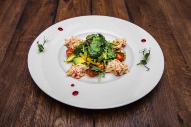 Kiraz domatesli yengeç ve avokado salatası, kiraz soslu karışık salata. Tahta bir masada..