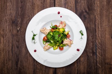 Kiraz domatesli yengeç ve avokado salatası, kiraz soslu karışık salata. Tahta bir masada..