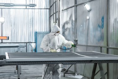 Elinde endüstriyel spreyler olan bir boyacı..