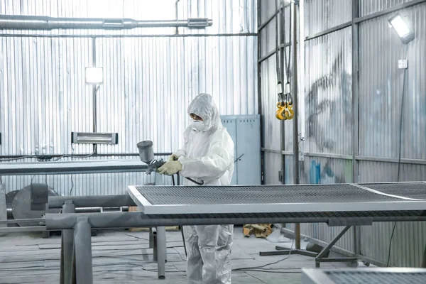 Elinde endüstriyel spreyler olan bir boyacı..