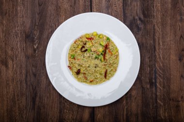 Tahta bir masada beyaz tabakta kral yengeci ile İtalyan pilavı..