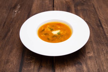 Tahta bir masada beyaz bir tabakta sebze çorbası. Geleneksel İtalyan yemekleri, restoran menüsü konsepti.