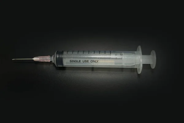 Injekční jehla lékařský nástroj v černém pozadí obrázek detailní — Stock fotografie