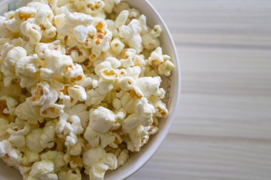 Ahşap masa üzerinde beyaz kase closeup içinde patlamış mısır