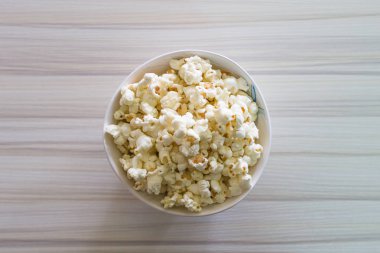 Ahşap masa üzerinde beyaz kase closeup içinde patlamış mısır