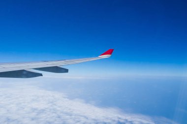 Beyaz bulutlar ve mavi gökyüzü görünümü uçak penceresinden .