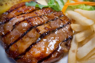 Beyaz plaka yakın görüntü üzerinde biftek ızgara domuz pirzola